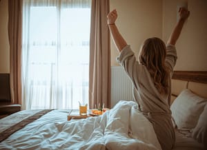 bed and breakfast roma centro, una ragazza su un letto che si stiracchia guardando fuori dalla finestra